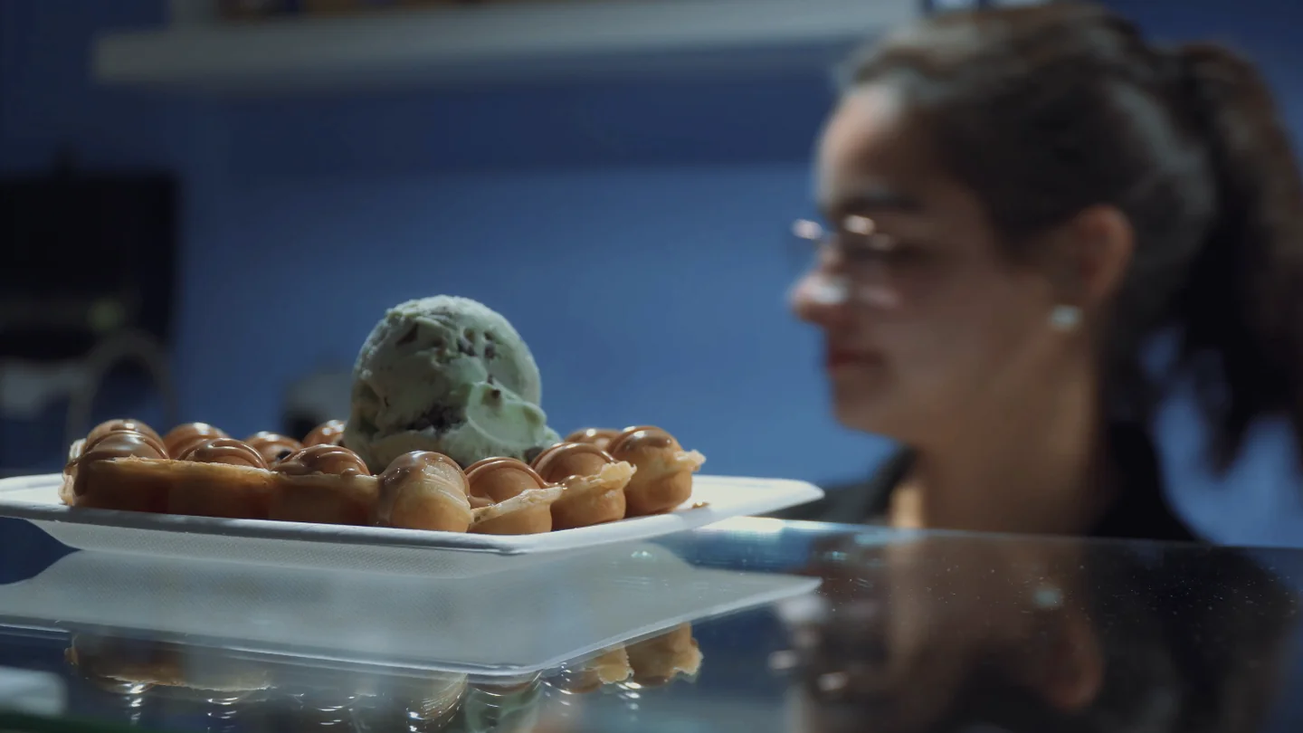 Waffle bubble con helado de menta y una clienta al fondo.