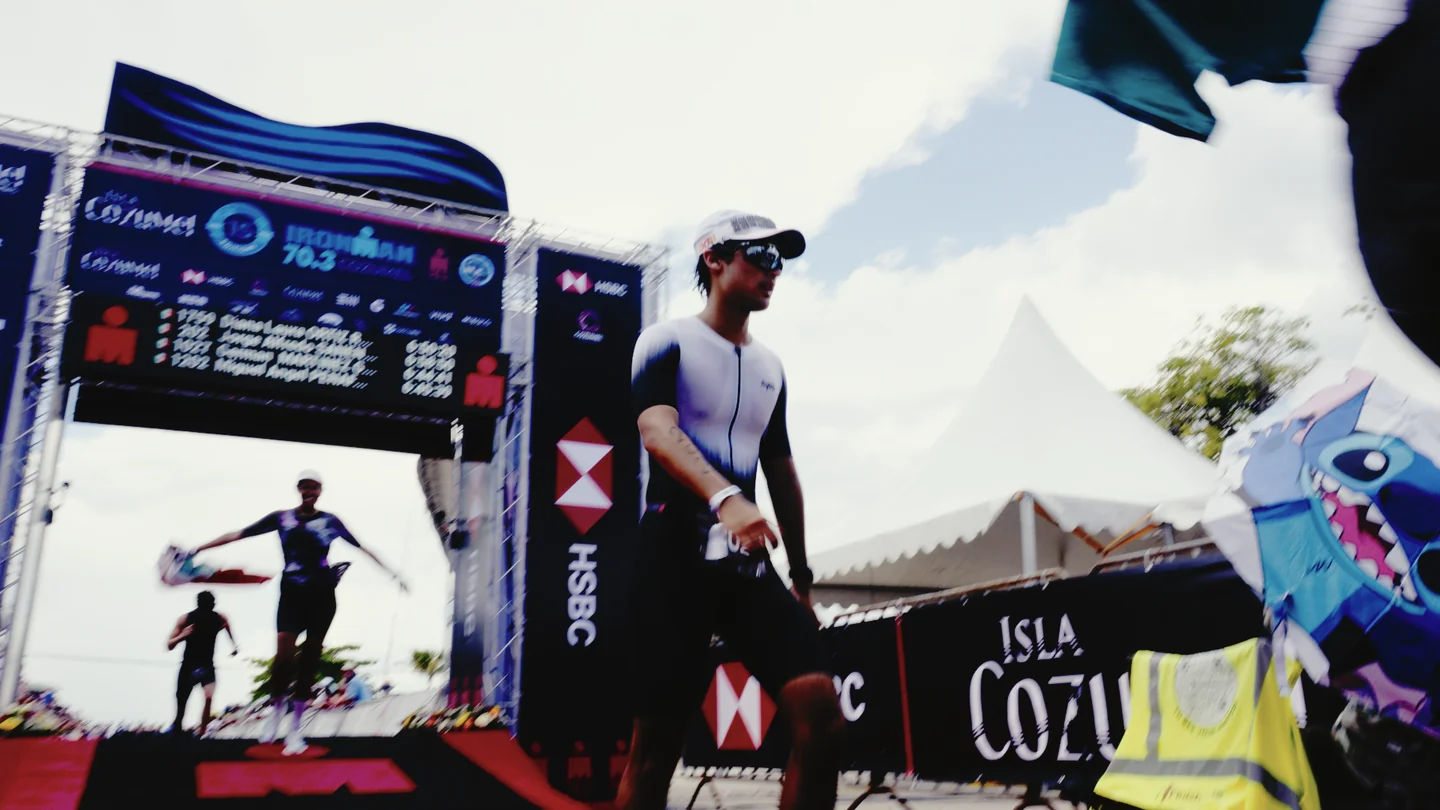 Hombre con gorra blanca junto al arco de llegada de la competencia.