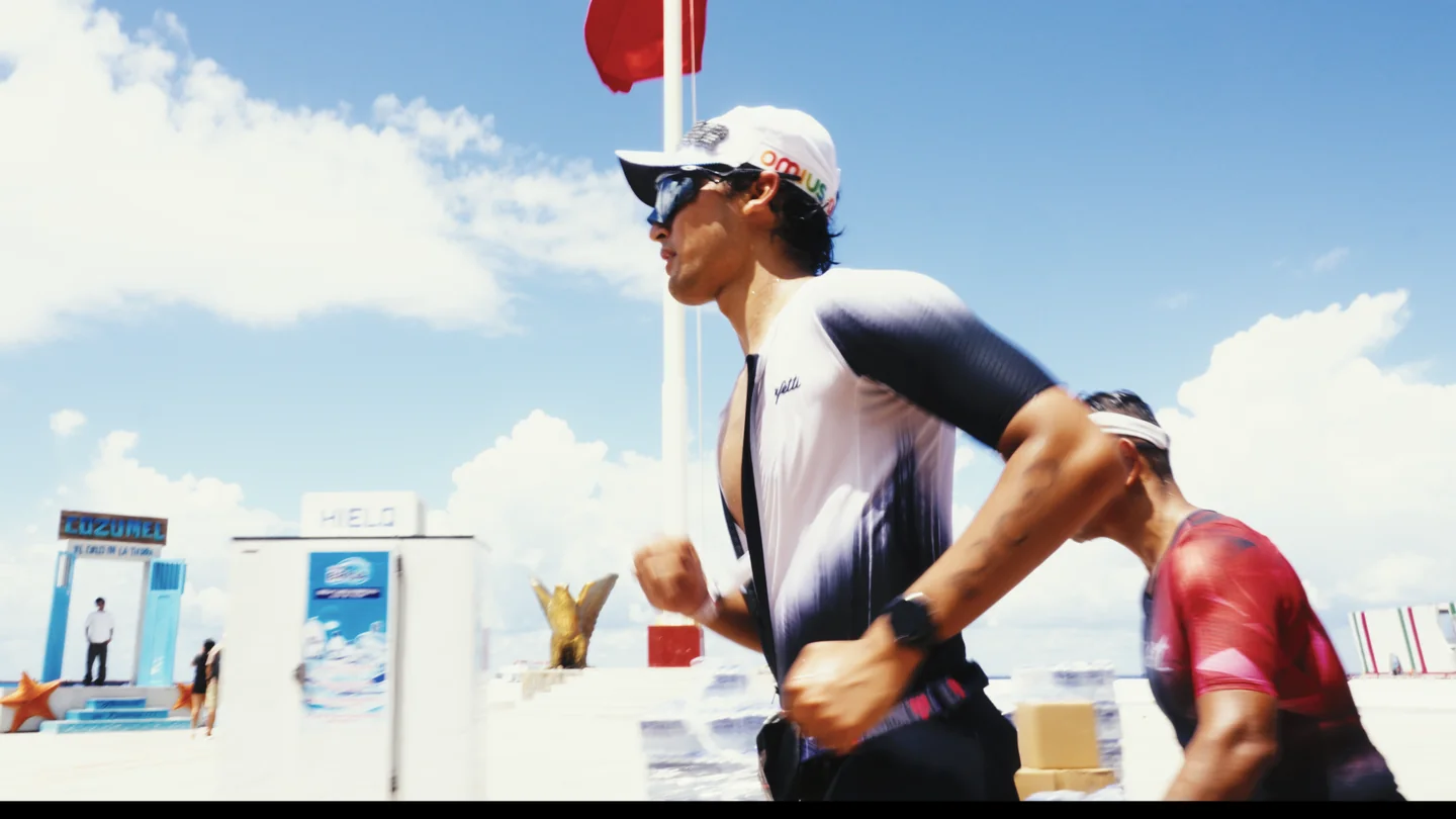 Hombre corre con gafas oscuras bajo el cielo azul.