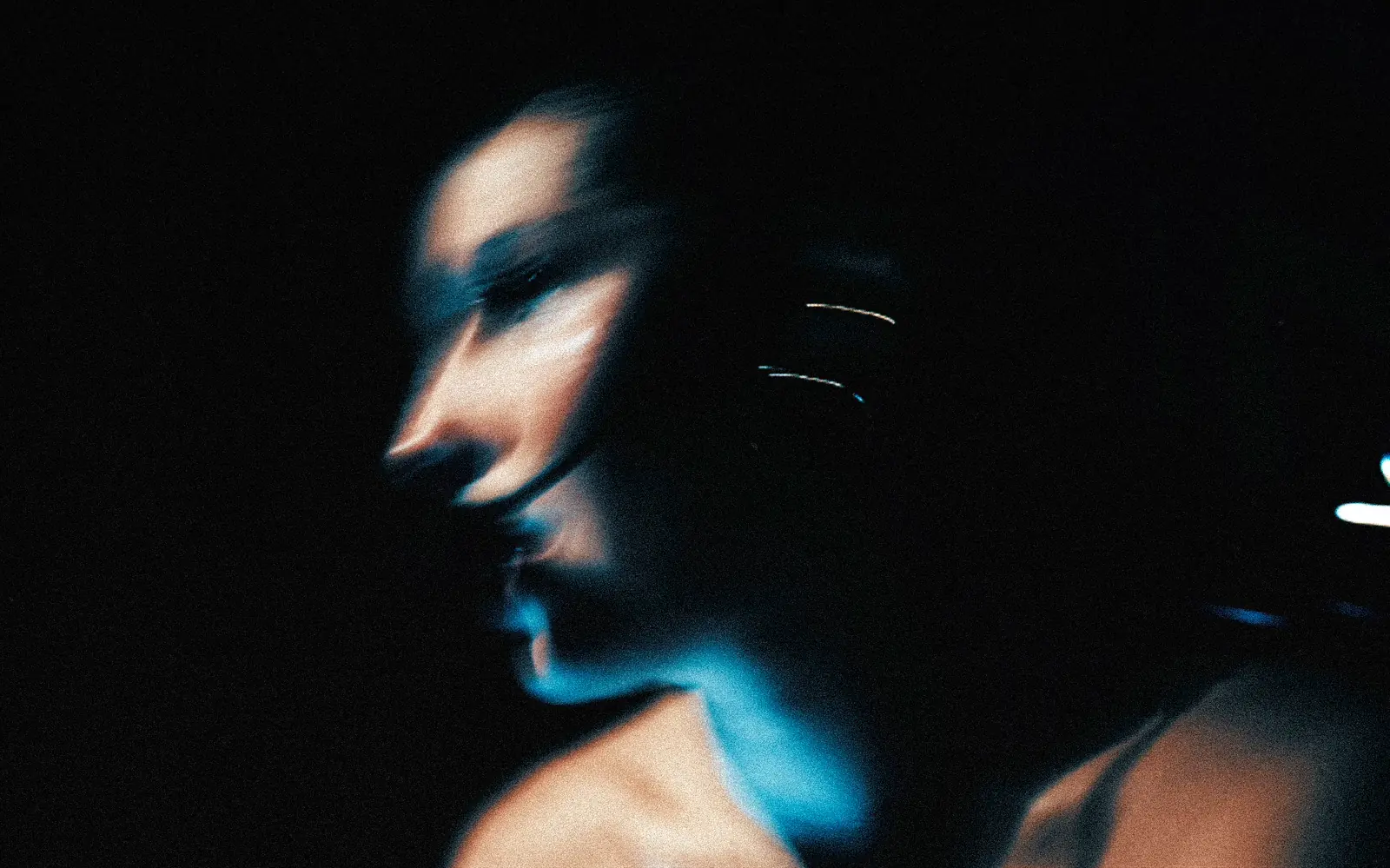 Retrato en movimiento de Mia Malacara iluminada en azul dentro del estudio.