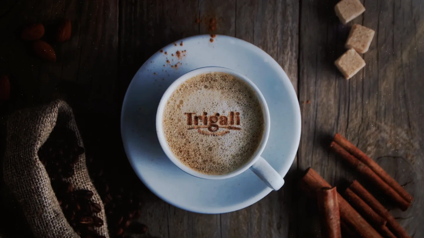 Taza de café con el logotipo de Trigali vista desde arriba sobre madera.